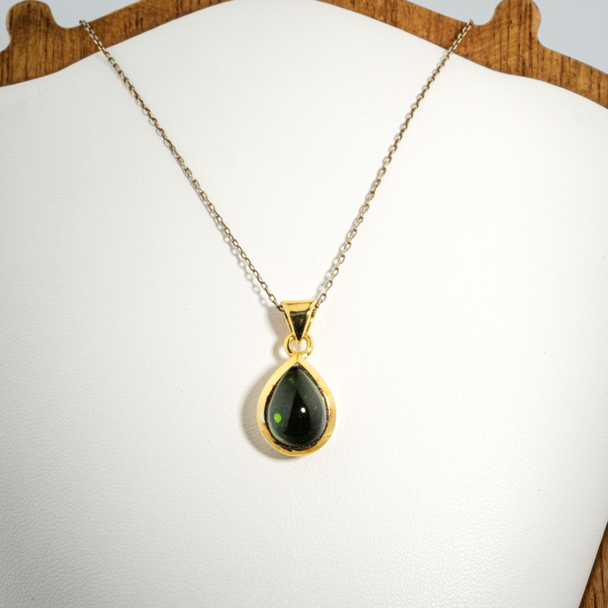 A gold-plated 925 sterling silver women's pendant featuring a natural pear-shaped cabochon dark green tourmaline gemstone in a bezel setting.