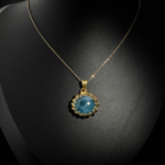 Natural oval cabochon deep blue aquamarine gemstone pendant necklace with braided gold plated 925 silver setting on white satin.