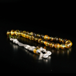 Genuine round fossil Baltic amber 33 prayer beads tesbih with 925 sterling silver tassel on mirror reflection and white satin.
