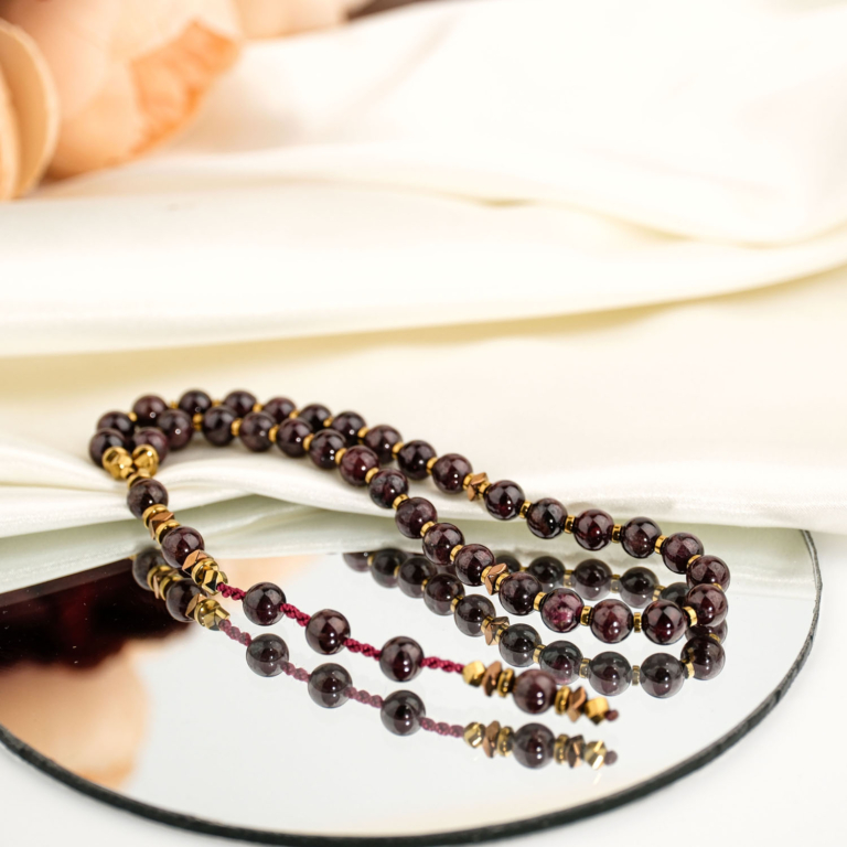Genuine natural deep red garnet and golden hematite faceted bead 33 prayer beads tasbih black background.