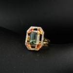Natural emerald cut green tourmaline ring accented with marquise yellow sapphire and genuine diamonds in gold plated 925 silver on white silk.