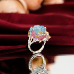Hand carved blue aquamarine peony flower and pink tourmaline butterfly statement ring in 925 sterling silver on red velvet.