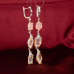 Genuine natural pink morganite and light blue topaz gemstone long dangle 925 sterling silver earrings red velvet background.