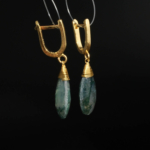 Natural faceted teardrop moss agate earrings with gold wire-wrap in gold-plated 925 silver on white satin