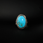Natural oval cabochon Persian Neyshabur turquoise statement ring in rope-edge 925 sterling silver on white satin.