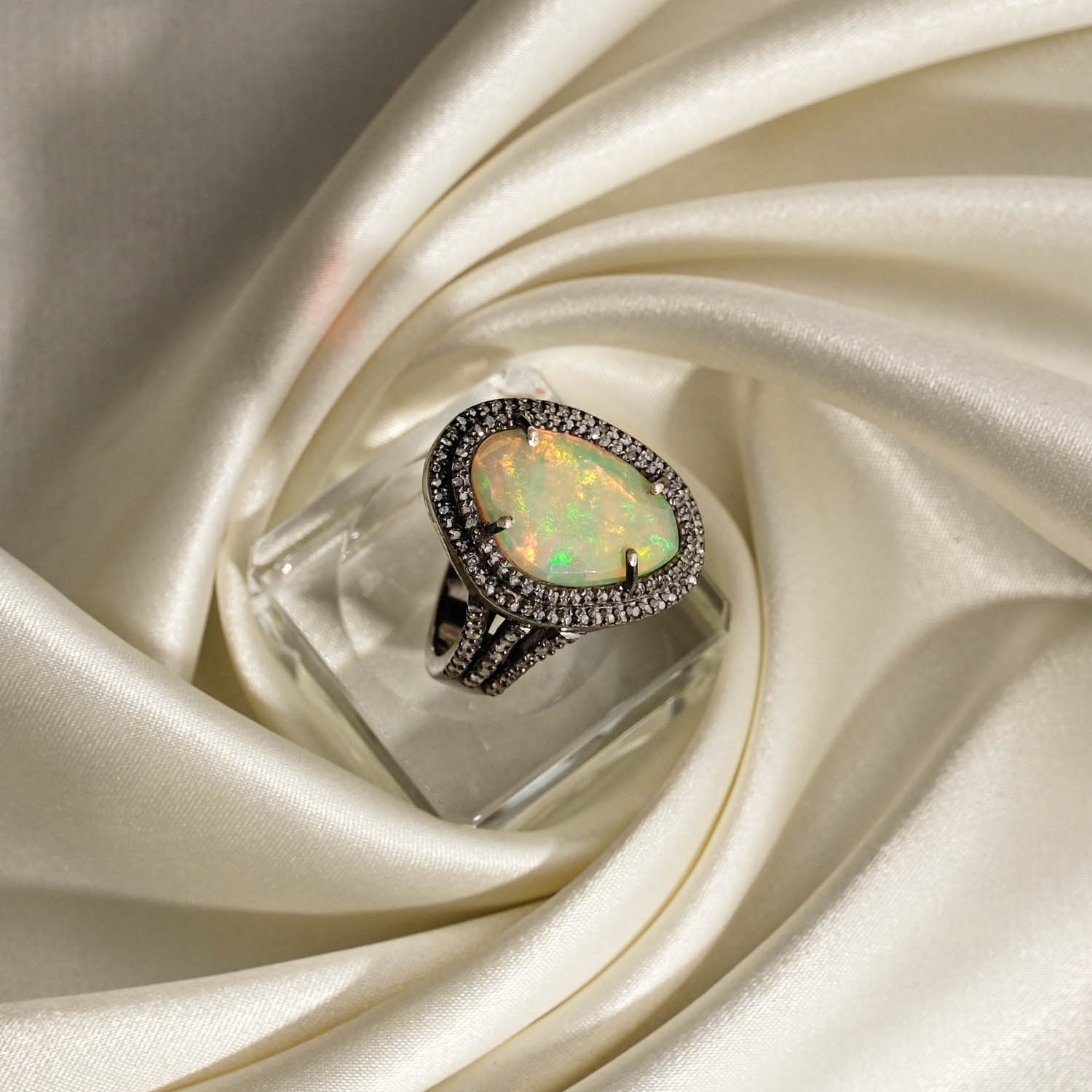 natural-opal-gemstone-teardrop-diamond-mount-antique-silver-ring Orijinal doğal damla kesim renk oyunlu opal taşı elmas montürlü 925 ayar gümüş antika kadın yüzük saten kumaş fon çekimi