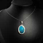 Natural oval cabochon Nishapur Persian turquoise gemstone halo pendant necklace in 925 sterling silver on white satin