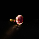 Genuine natural deep red oval faceted ruby gemstone ring with pink halo yellow gold plated 925 sterling silver black background.