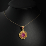 Natural round cabochon ruby medallion pendant necklace with filigree detail in gold plated 925 silver on white satin