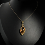 Natural faceted teardrop yellow citrine gemstone pendant necklace in 14k gold plated 925 silver on white satin.