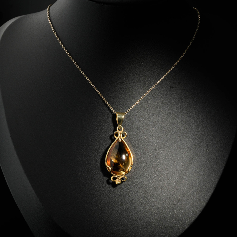 Natural faceted teardrop yellow citrine gemstone pendant necklace in 14k gold plated 925 silver on white satin.