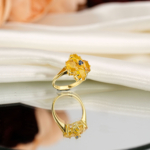 Genuine natural yellow sapphire oval cluster with blue sapphire center yellow gold plated 925 sterling silver statement ring black background.