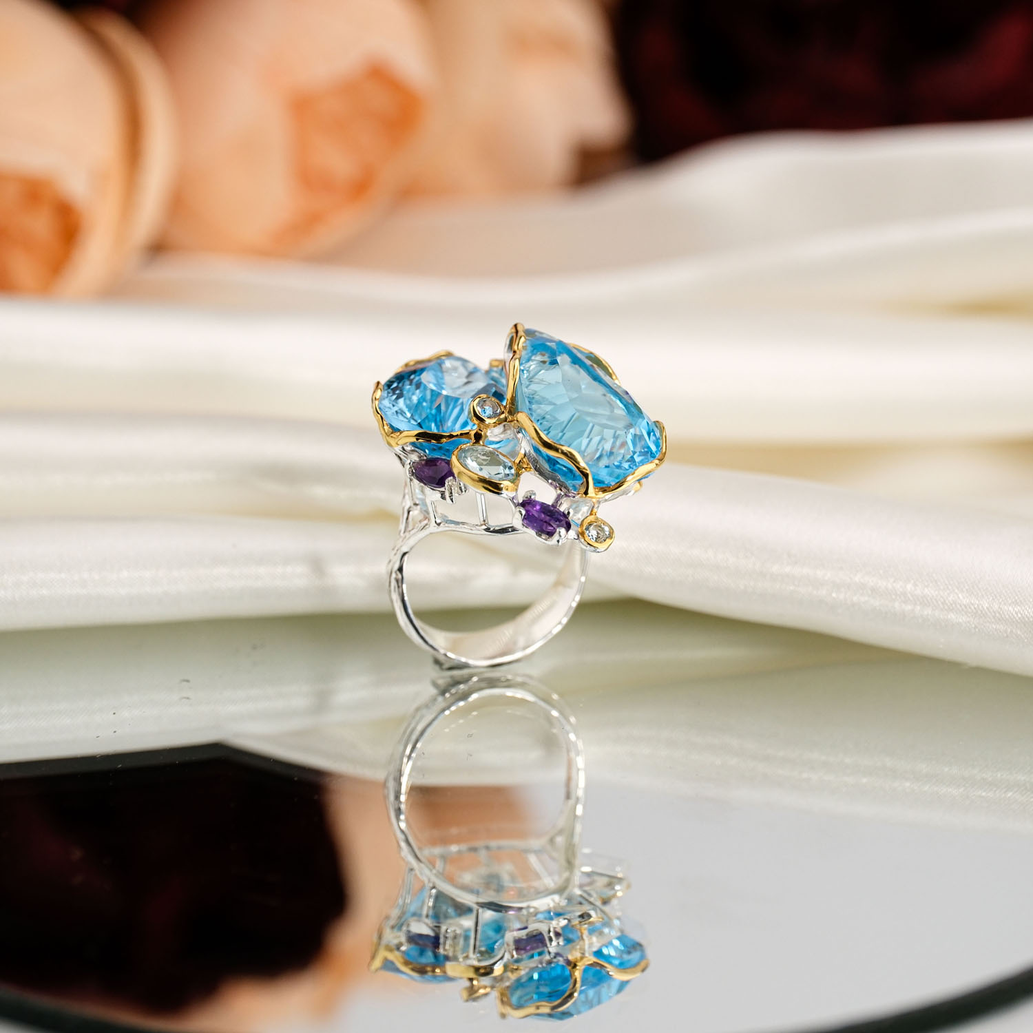 orijinal-blue-topaz-ametist-dogal-tas-cift-damla-925-ayar-gumus-yuzuk Orijinal doğal canlı mavi çift damla faset blue topaz ve mor ametist taşlı iki renkli 925 ayar gümüş kadın tasarım yüzük beyaz fon açılı çekim.