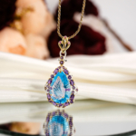 Carving çiçek oymalı doğal buz mavisi damla blue topaz ve ametist halo taşlı 925 ayar gümüş kadın kolye ahşap büst stüdyo çekimi.