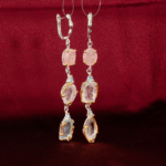Orijinal doğal pastel pembe morganit ve açık mavi topaz taşlı çok katlı sallantılı 925 ayar gümüş kadın küpe gri fon çekimi.