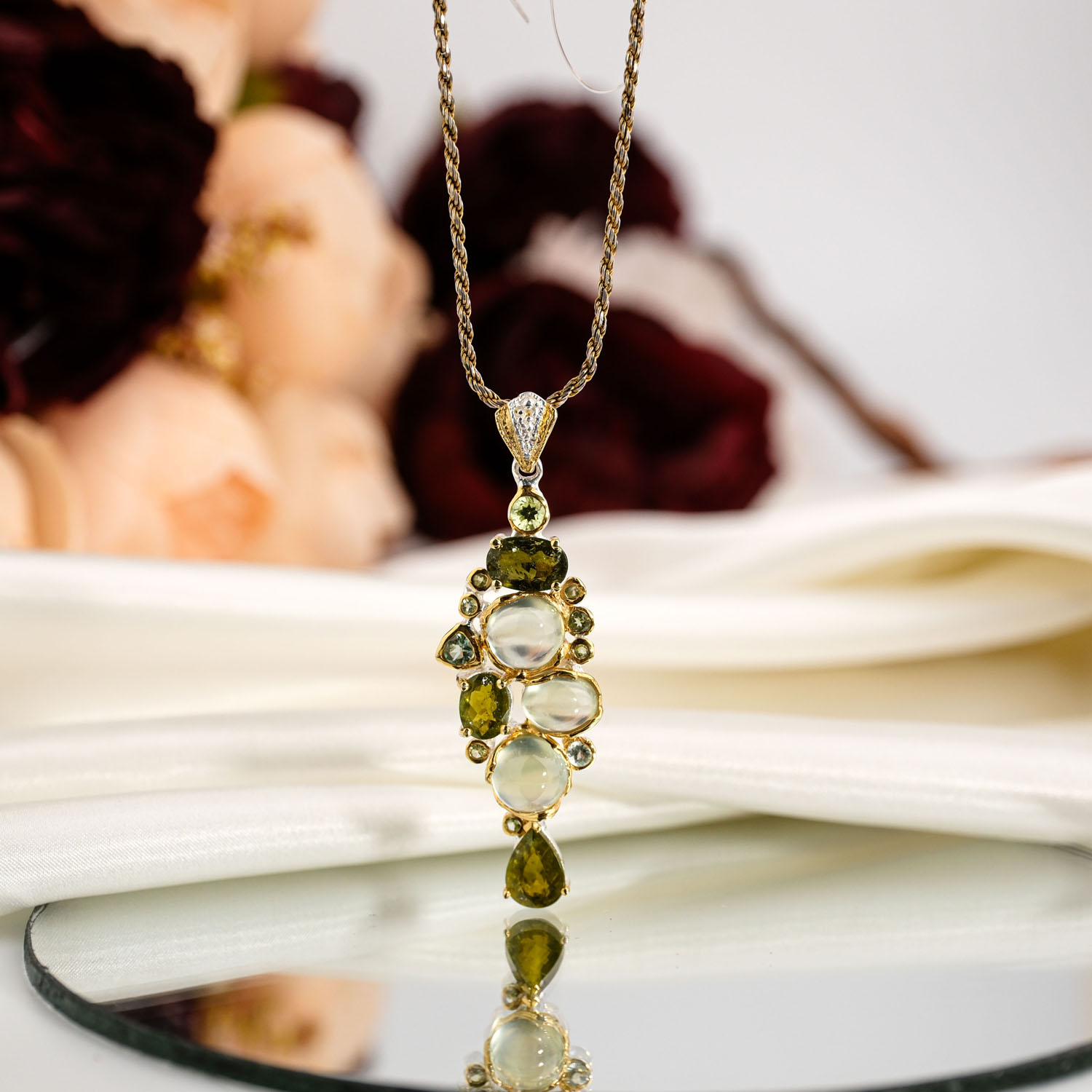 orijinal-zebercet-peridot-prehnit-dogal-tas-salkim-925-ayar-gumus-kolye Orijinal doğal kabaşon prehnit ve faset damla zebercet peridot taşlı sarı altın kaplama 925 ayar gümüş kadın kolye ahşap büst stüdyo çekimi.