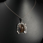 Pendentif vintage pour femme en argent 925 oxydé orné d'une agate rubanée marron et d'un papillon délicat.