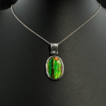 Pendentif artisanal en argent massif 925 avec opale boulder naturelle aux reflets verts et bleus.