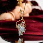 Pendentif d'exception en argent 925 orné de feuilles d'aigue-marine sculptées à la main et de saphirs bleus sur fond miroir.