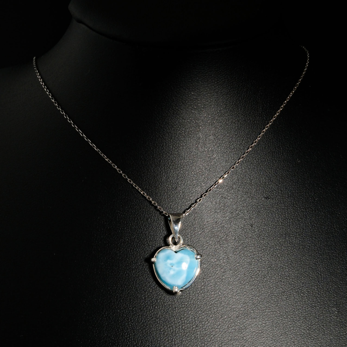 Pendentif de prestige en argent 925 orné d'un larimar naturel bleu ciel taillé en coeur sur fond noir.