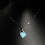 Pendentif de prestige en argent 925 orné d'un larimar naturel bleu ciel taillé en coeur sur fond noir.
