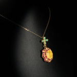 Somptueux pendentif en argent 925 plaqué or orné d'un saphir jaune facetté entouré de grenats et bélière fleur en émeraude.