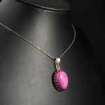 Pendentif féminin raffiné en argent 925 orné d'un rubis naturel ovale serti d'une monture dentelle.