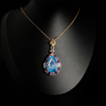 Pendentif de prestige en argent 925 orné d'une topaze bleue sculptée main en poire et améthystes violettes sur fond noir.