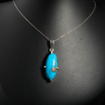 Pendentif unisexe en argent 925 orné d'une turquoise naturelle ovale avec inclusions de pyrite dorée.