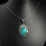 Pendentif unisexe en argent 925 orné d'une turquoise naturelle ovale avec matrice sertie d'un cadre torsadé.