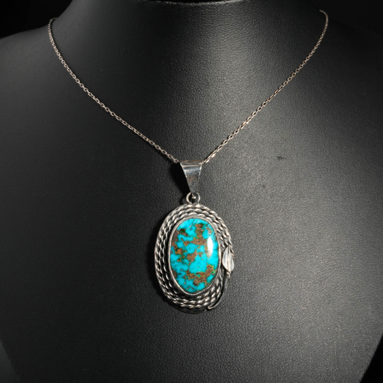 Pendentif unisexe en argent 925 orné d'une turquoise naturelle ovale avec matrice sertie d'un cadre torsadé.