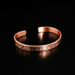 Pure solid copper adjustable engraved cuff bracelet on mirror reflection and white satin.