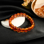 Sertifikalı orijinal doğal bal ve konyak sarısı kehribar oval rolex model bakla kesim unisex bileklik siyah fon çekimi.